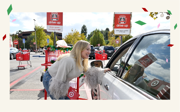 Actress Hilary Duff handing a Target GiftCard to a Target Drive Up guest in their car.