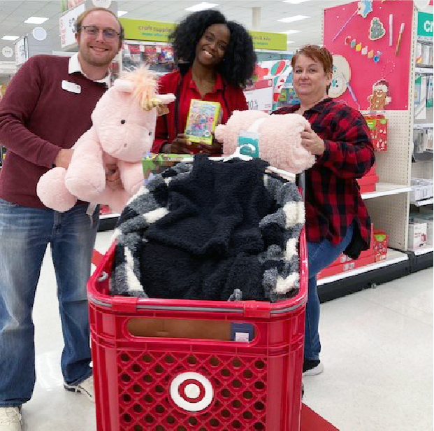 Three members of our D’Iberville, Mississippi, store smile as they hold up gifts.