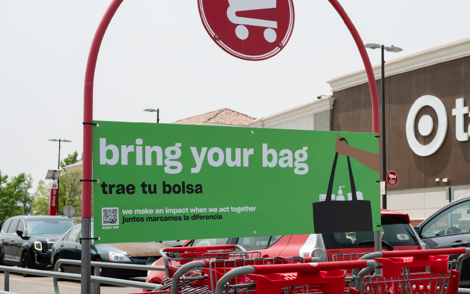 A sign at a cart corral in front of a Target store says “Bring your bag.”