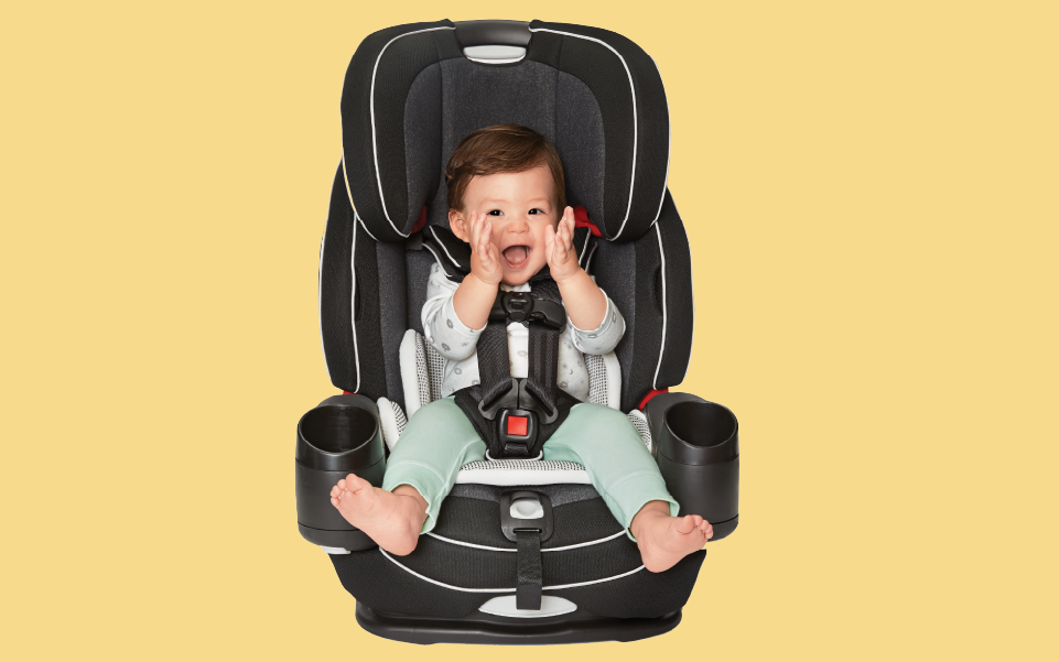 A smiling baby sits in a car seat.