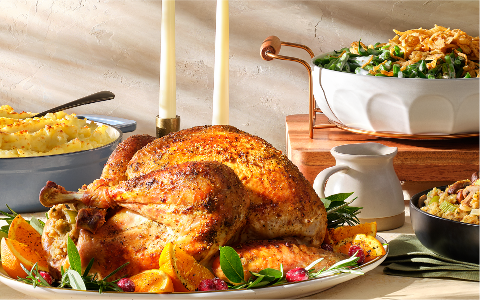 A Thanksgiving feast, including a cooked turkey dish, seasoned mashed potatoes and more sides.