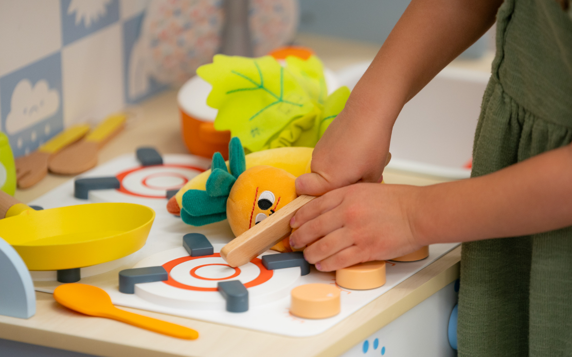 A child plays with a Gigglescape pretend food set.