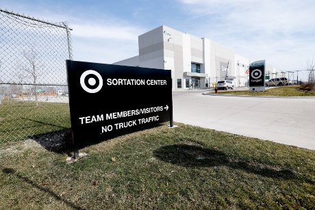 A sign in front of a sortation center announces: “Sortation Center, Team members/visitors, No truck traffic.”