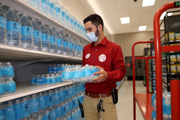 a person wearing a mask and holding a blue object in a store