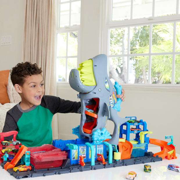 A child plays with a shark-themed car set.