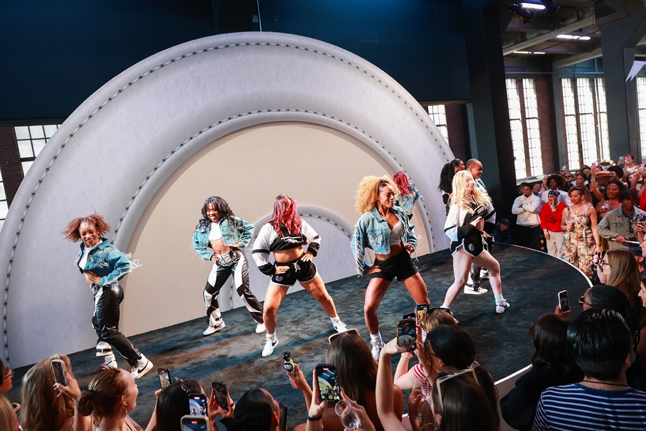 Eight people in dance on a stage for a crowd in front of a Target logo