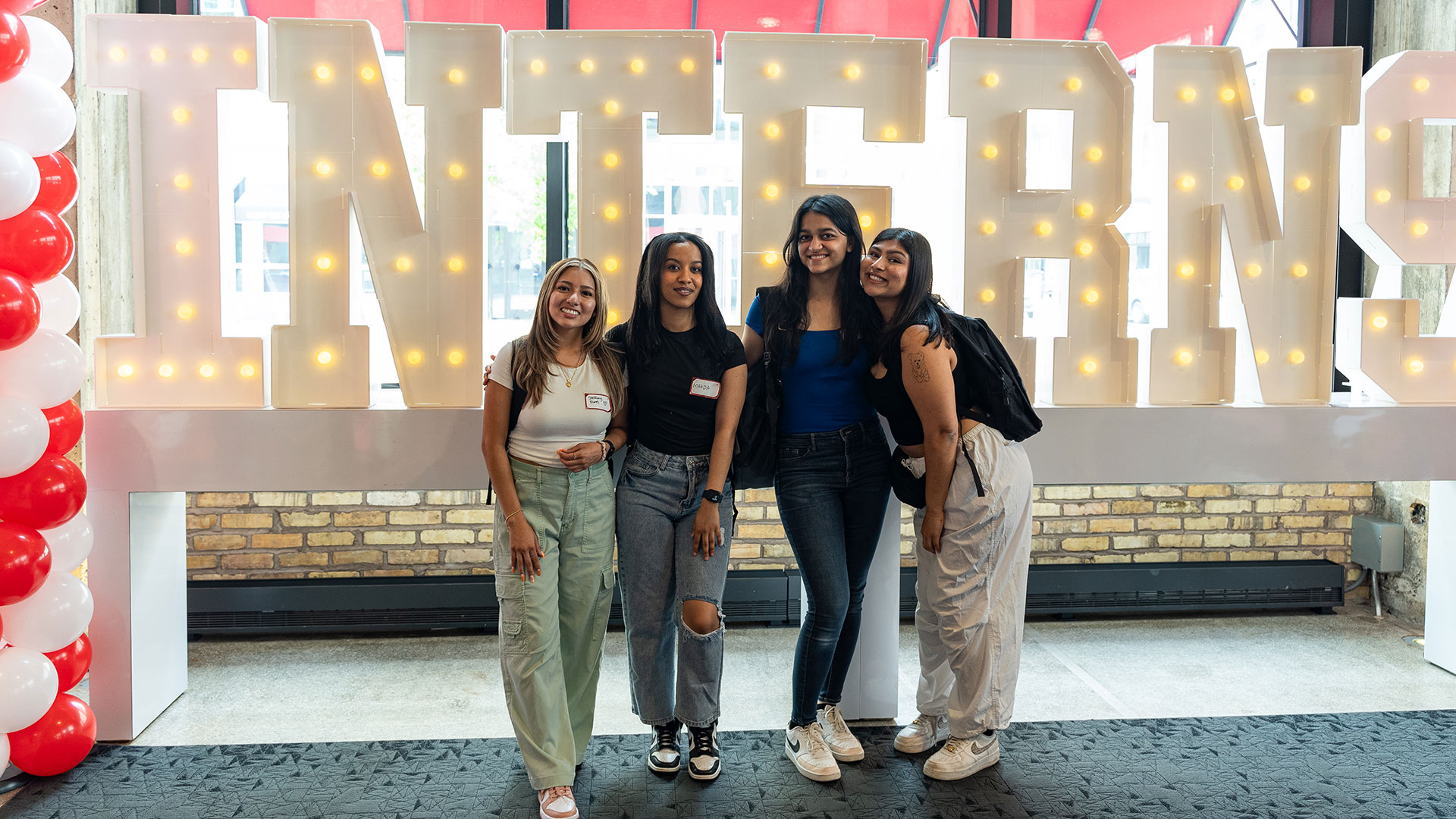 A group of Target interns posing in front of a large "Interns" sign.