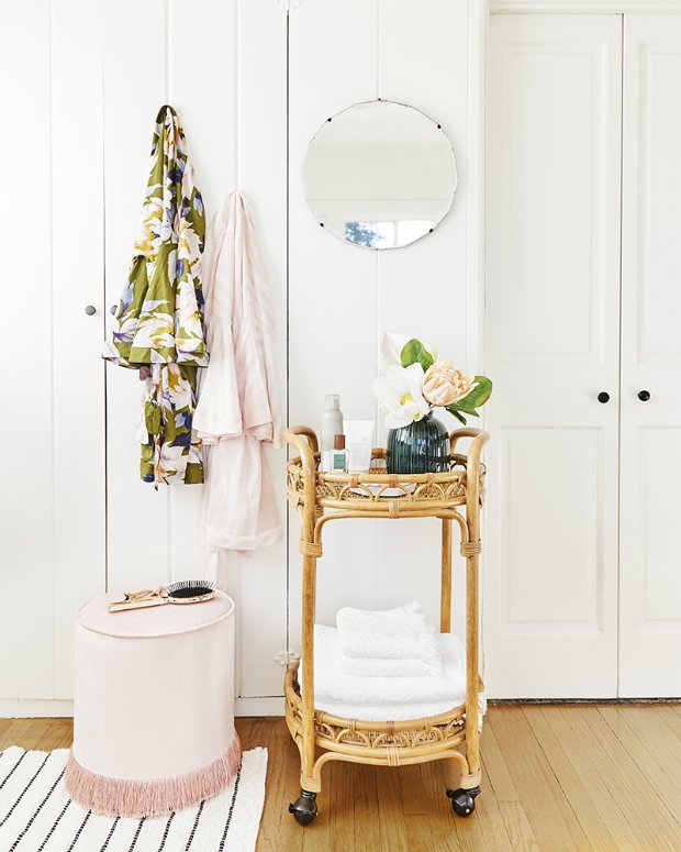 a chair and a table in a room with a mirror and a vase