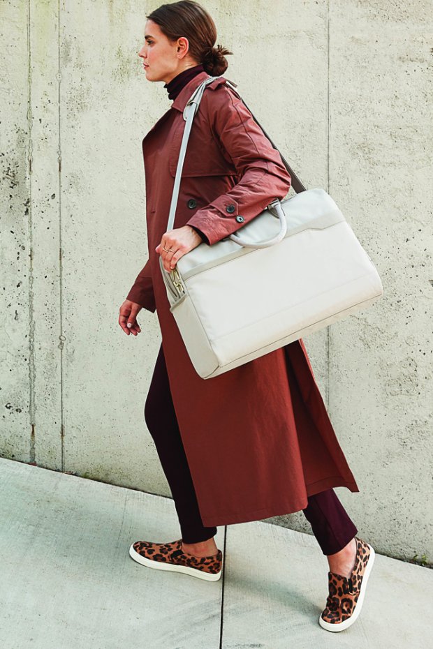 a woman in a skirt carrying a white purse