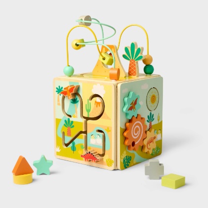 An white background displays a wooden cube with colorful shaped cutouts and artistic designs.
