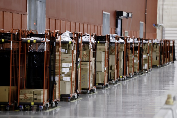 Several racks filled with boxes of orders are lined up for drivers.