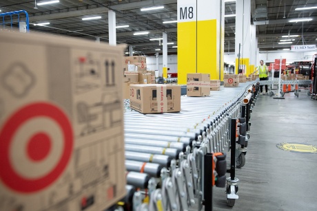 Several boxes with the Target Bullseye logo move down a conveyor at a sortation center.