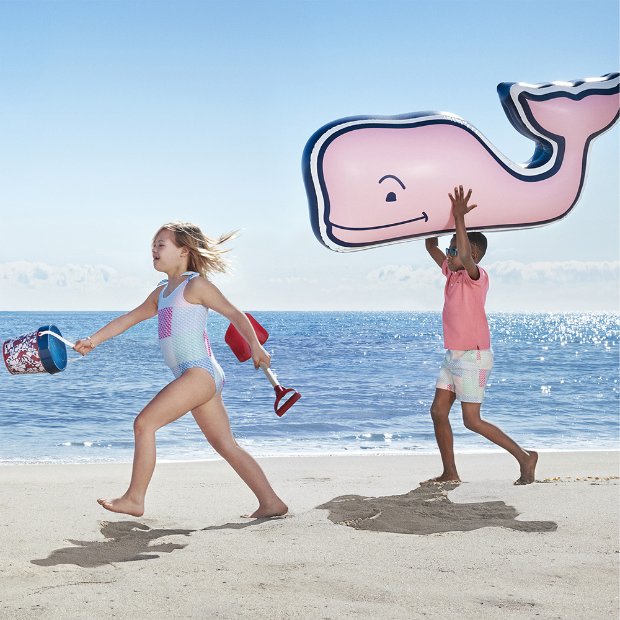 a couple of kids playing with kites on a beach