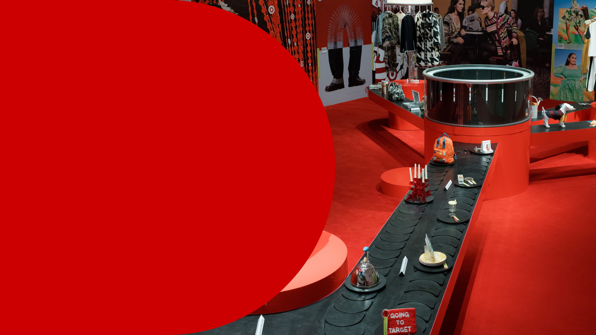 Hero image with the text “Guest Experience: Inside Target’s Next Chapter of Great Design for All” beside a vivid red Target by Design exhibit at New York City’s New Museum, featuring circular display structures, a long black platform lined with curated objects, fashion imagery and colorful products throughout the space.