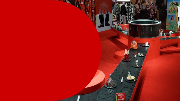 Hero image with the text “Guest Experience: Inside Target’s Next Chapter of Great Design for All” beside a vivid red Target by Design exhibit at New York City’s New Museum, featuring circular display structures, a long black platform lined with curated objects, fashion imagery and colorful products throughout the space.