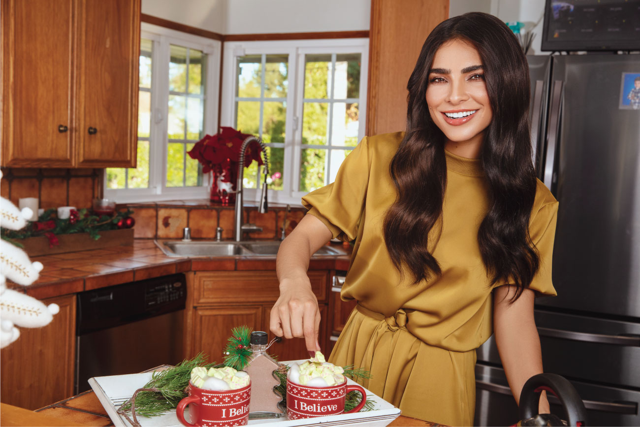 Alejandra makes two cups of hot chocolate in her kitchen