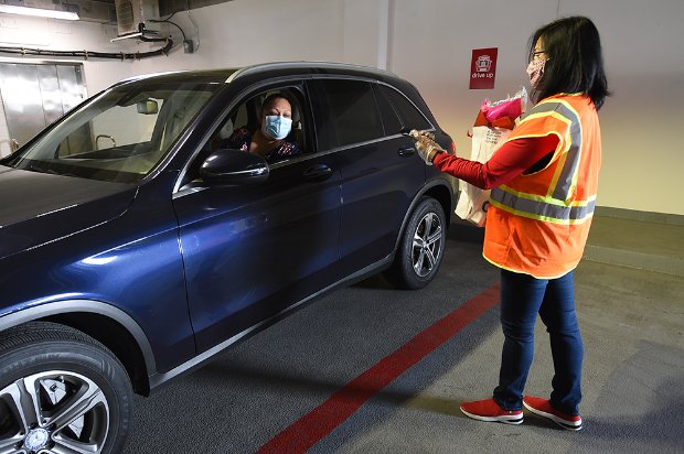 a woman in an orange vest standing next to a car