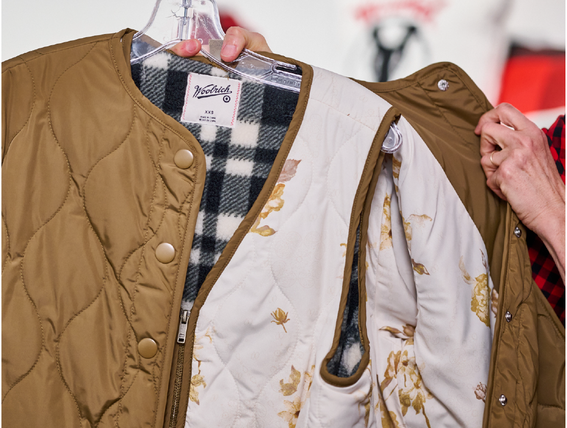 A brown Woolrich x Target quilted jacket on a hanger.