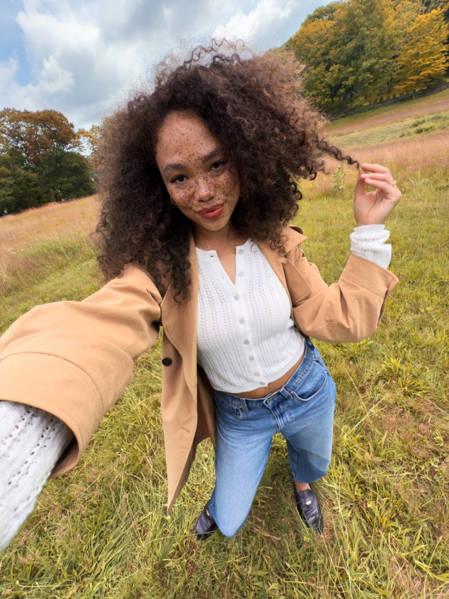 A person takes a selfie in a field.