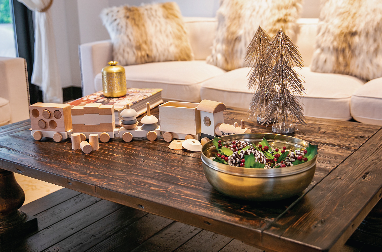 A wooden train is displayed on a coffee table with luxe gold accents
