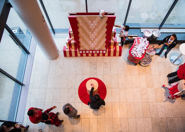 a group of people sitting on the floor in front of a large red sign