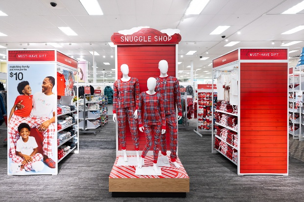 Three mannequins wearing matching plaid pajamas are posed in front of a sign that says “Snuggle Shop.”