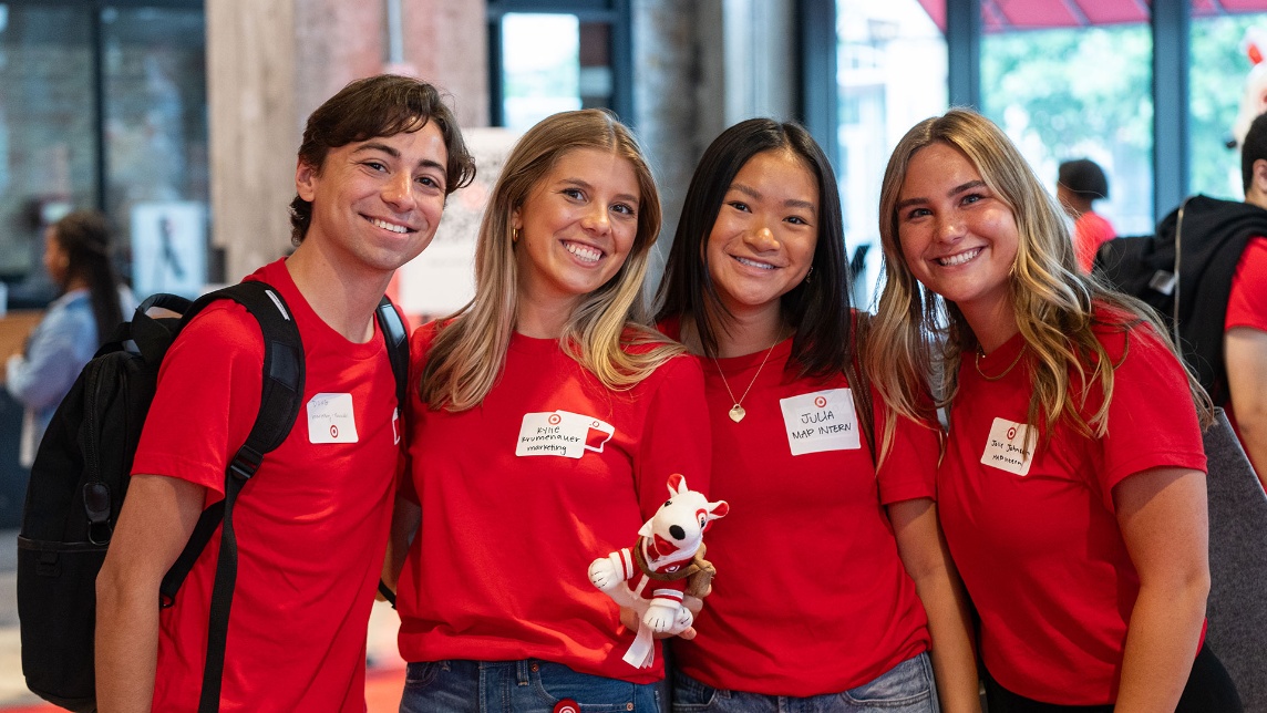 A group of Target interns pose for a picture with a small dog stuffed toy.