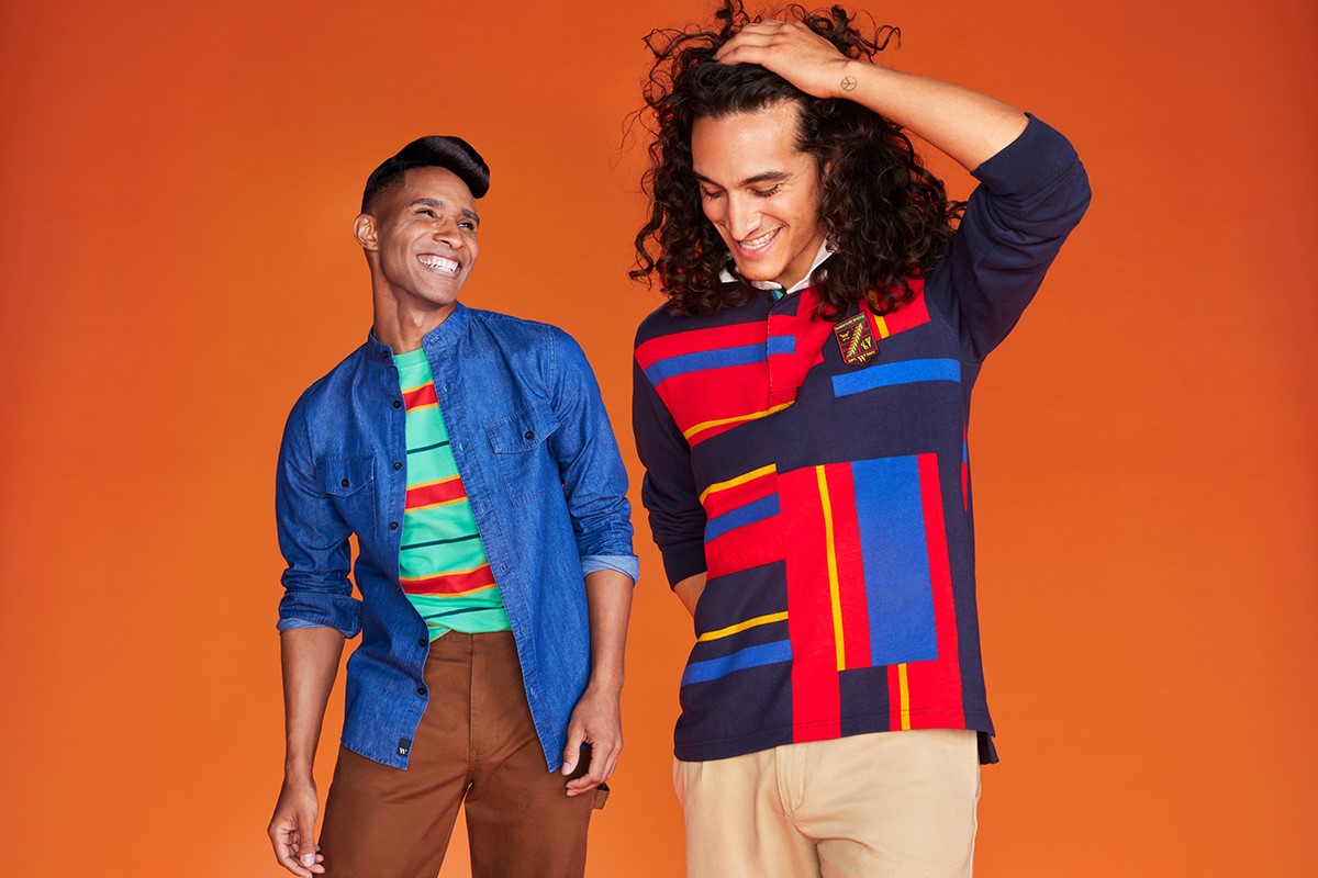 Two models in front of an orange background wearing colorful patterned shirts from the Houston White x Target collection.