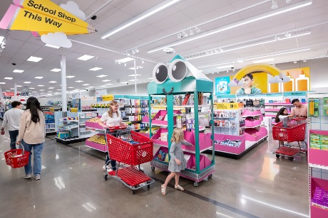 Parents and children shop together, surrounded by rows of back-to-school essentials.