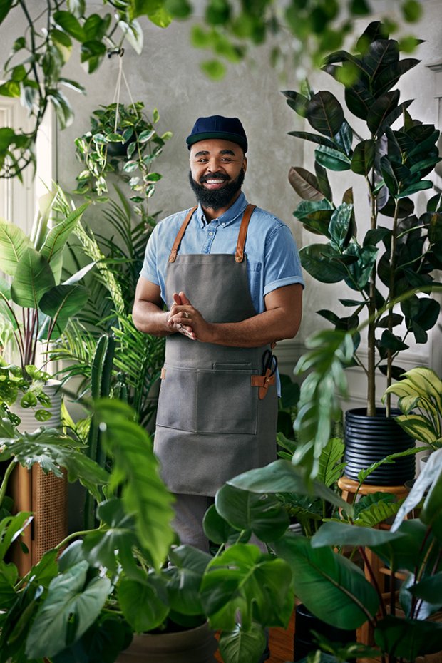 a man standing in front of a plant