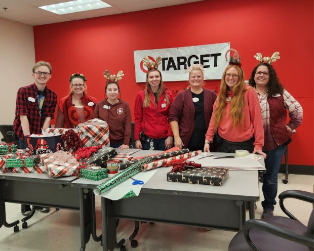 a group of people standing next to a table with food on it