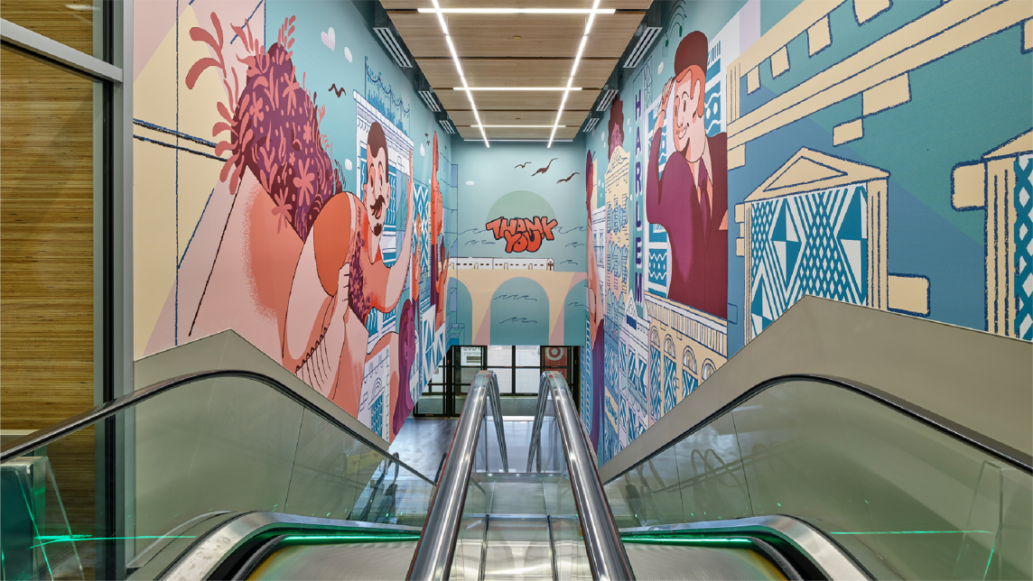 The escalator inside the Target store in Harlem, surrounded by murals.