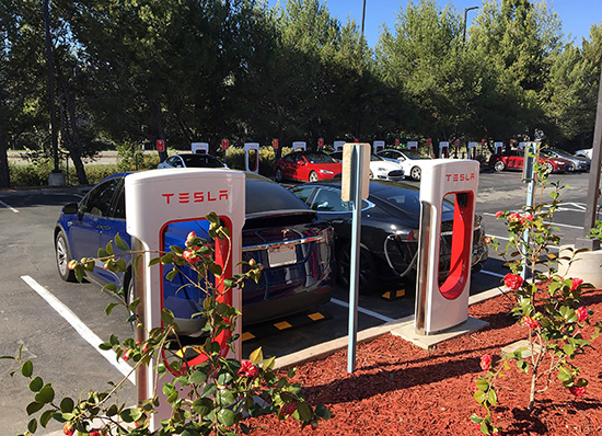 Two cars recharging at Tesla stations