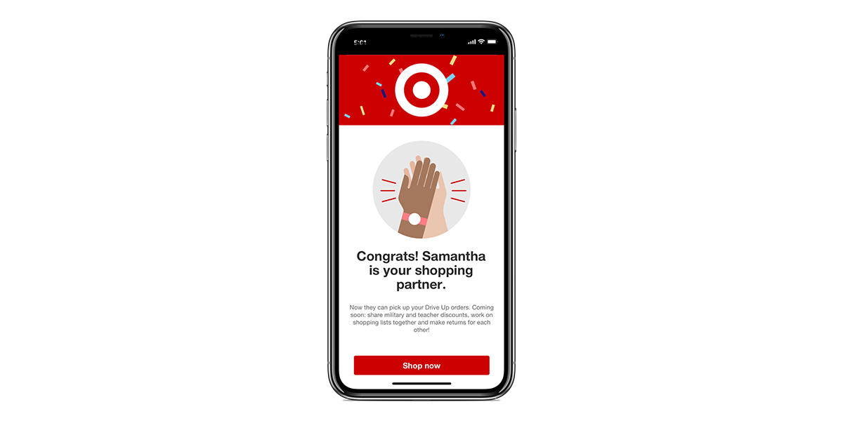 A cell phone with the Target app pulled up showing a notification that says “Congrats! Samantha is your shopping partner. Now they can pick up your Drive Up orders. Coming soon: share military and teacher discounts, work on shopping lists together and make returns for each other!” At the bottom, a button reads “Shop now.”