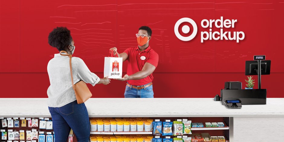 a man and a woman standing at a counter with a box of food