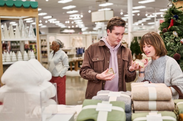 A detailed view of guests exploring holiday products in the Alpine Chalet display inside a Target store.