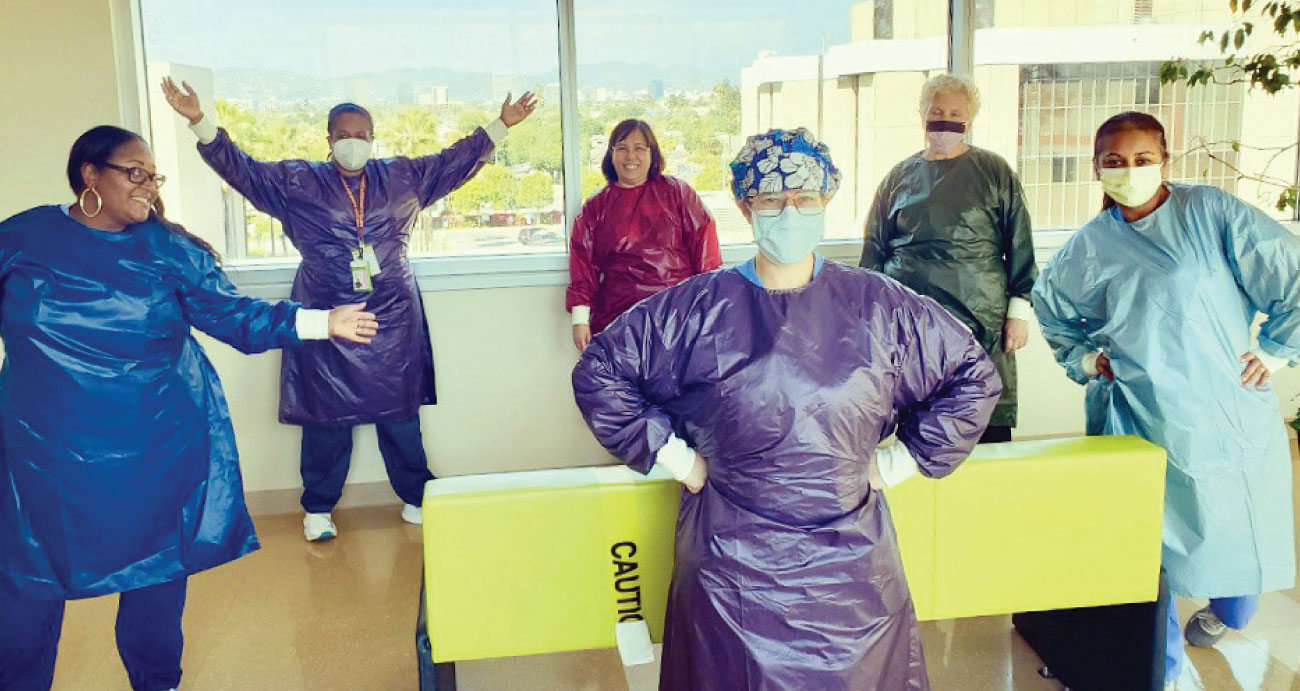 six medical professionals in plastic gowns and masks
