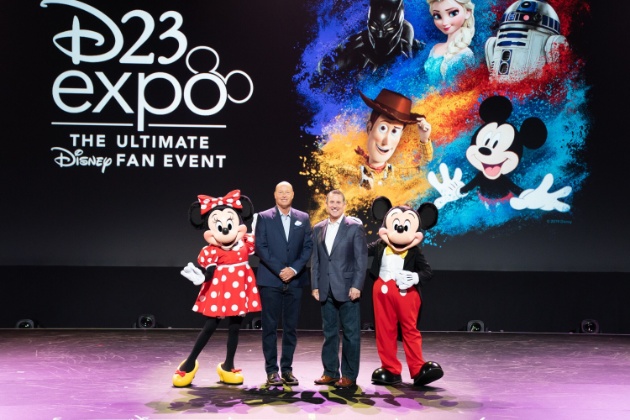 a group of people standing on a stage with a cartoon character