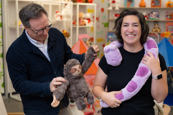 Jeff Carter holds a Gigglescape plush sloth and Ellen Rizzardi has a purple plush snake around her neck