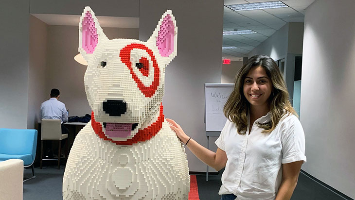 a female stands next to a bullseye dog made out of legos