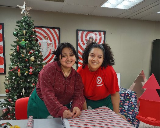 a person and a girl sitting at a table in front of a christmas tree