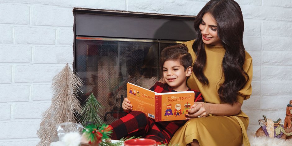 a person and a child sitting on a bench with a book