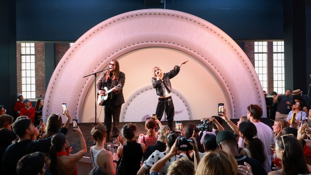Two people stand on a stage, one sings while the other plays guitar and sings. Behind them is a Target logo.