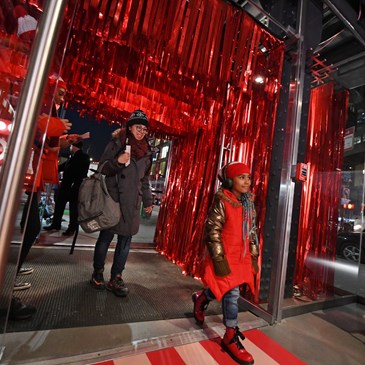 a woman taking a picture of a man in a red coat