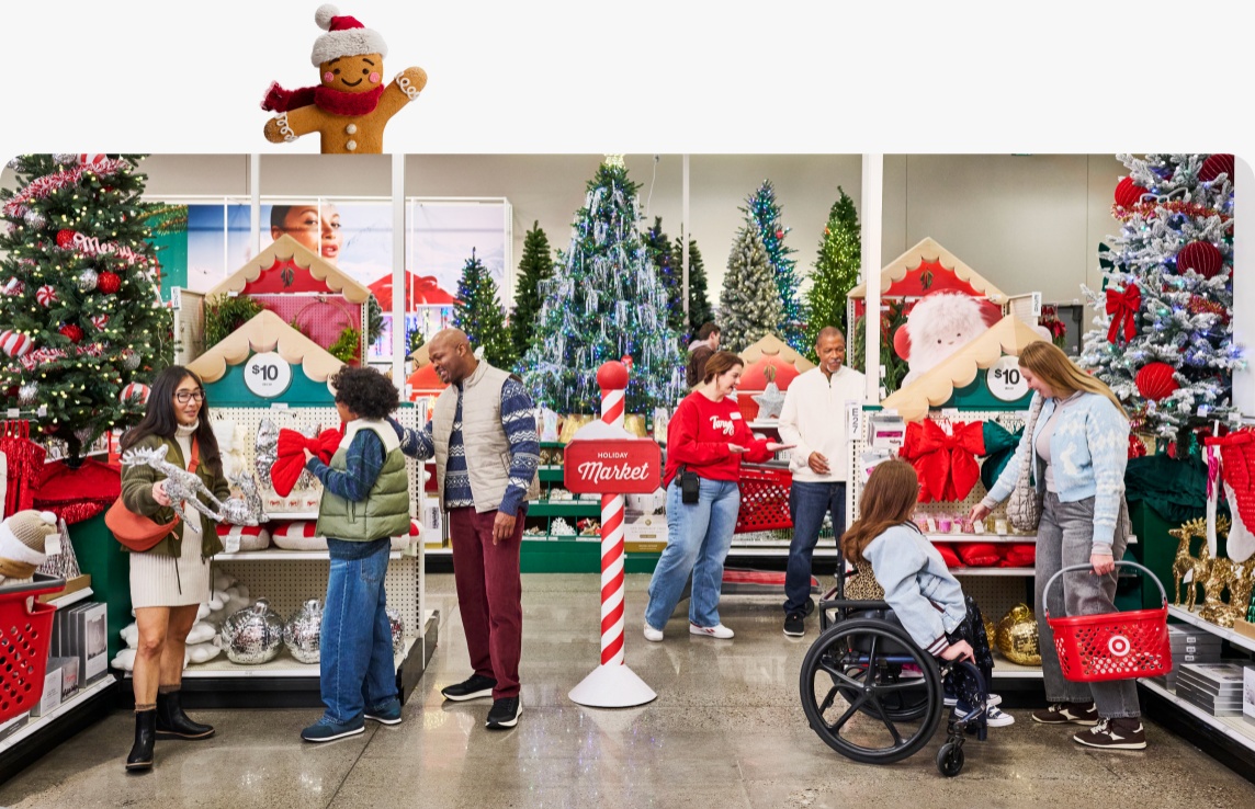 Shoppers look around the Alpine Market in a Target store, full of holiday decor and Christmas trees.