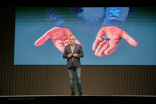 a person standing in front of a screen with a group of fish