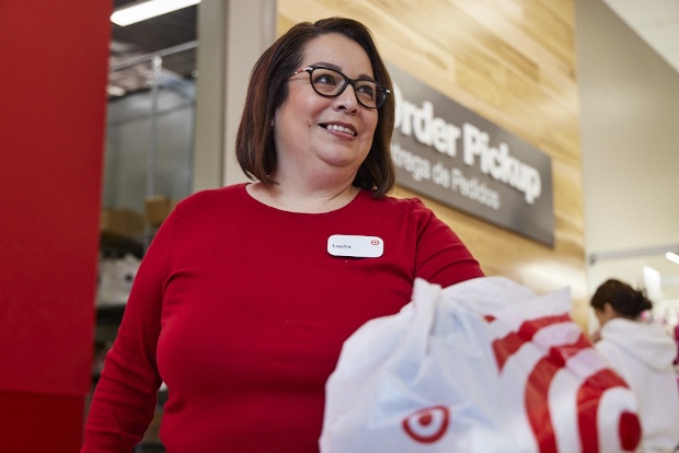 A Target team member with a Target bag is standing the Target Pick Up counter.