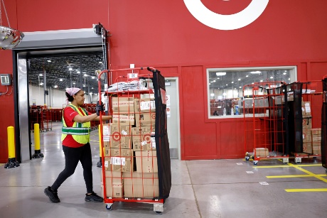 A team member pushes a rack filled with packaged guest orders.