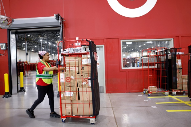 A team member pushes a rack filled with packaged guest orders.