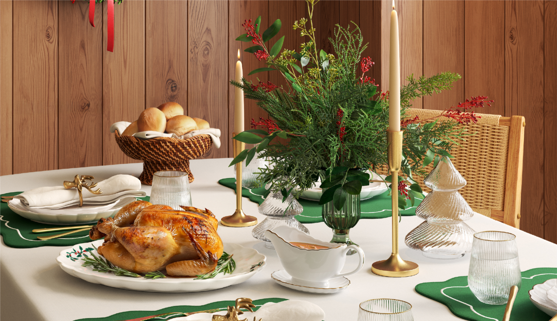 A holiday table set with a turkey, rolls and a seasonal centerpiece.